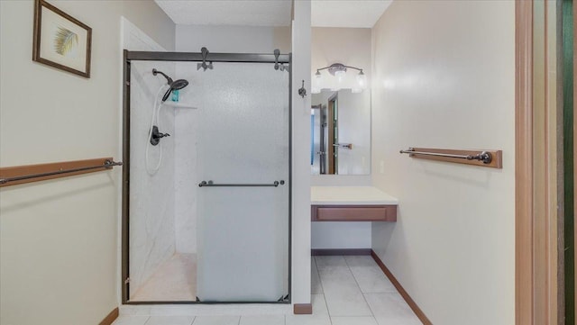 full bath with a shower stall, baseboards, and tile patterned flooring