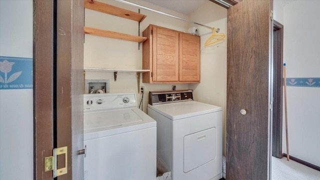 clothes washing area with washer and clothes dryer and cabinet space