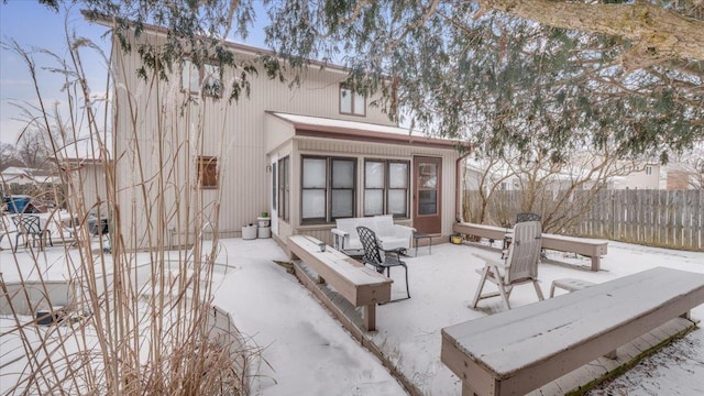 snow covered house with fence