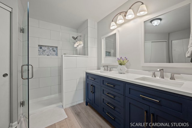 bathroom featuring hardwood / wood-style flooring, vanity, and an enclosed shower