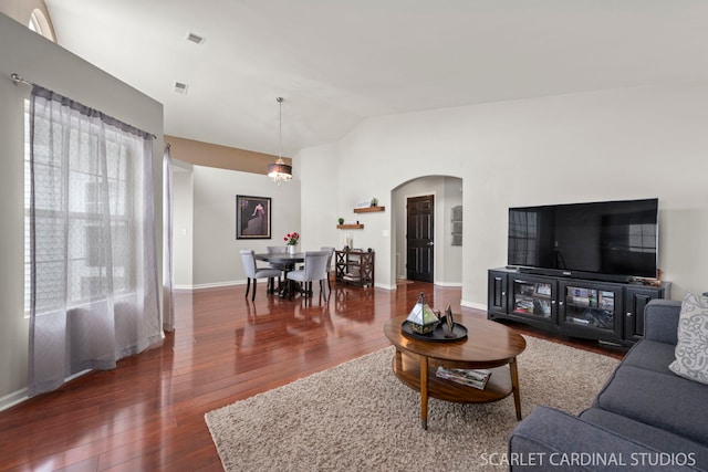 living room with lofted ceiling, dark hardwood / wood-style floors, and a chandelier