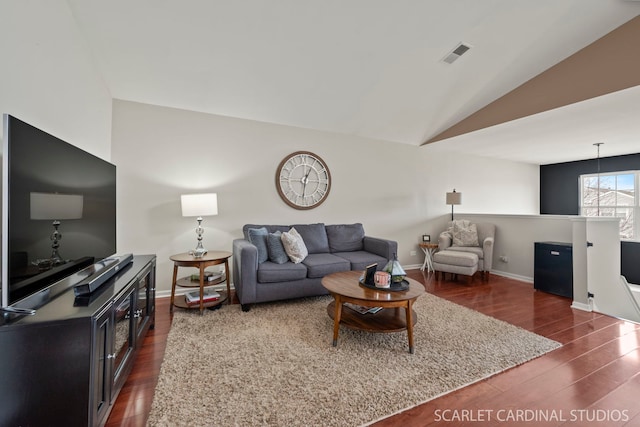 living room featuring dark hardwood / wood-style flooring and vaulted ceiling