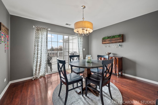 dining space featuring a notable chandelier and dark hardwood / wood-style floors