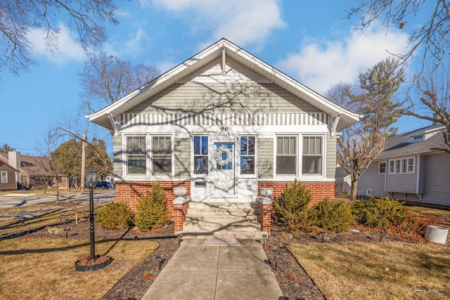 bungalow-style home featuring a front lawn