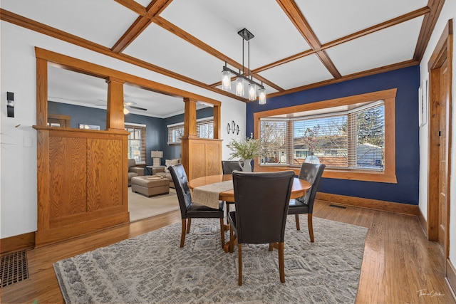 dining room with ornamental molding, coffered ceiling, a notable chandelier, and light wood-type flooring