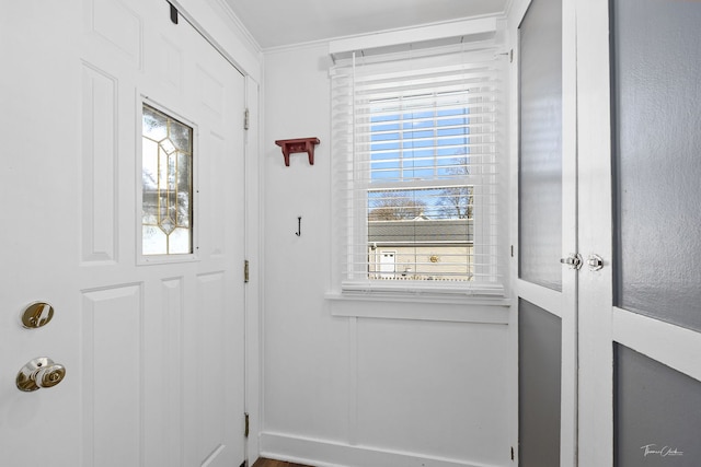 entryway with ornamental molding and plenty of natural light