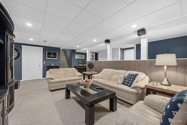 living room featuring light carpet and a drop ceiling