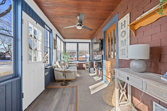 unfurnished sunroom with wood ceiling and ceiling fan