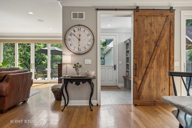 foyer featuring light hardwood / wood-style flooring, plenty of natural light, and a barn door