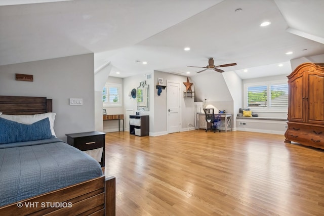 bedroom featuring multiple windows, ceiling fan, vaulted ceiling, and light wood-type flooring