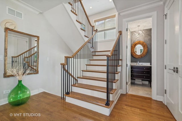 staircase featuring crown molding and hardwood / wood-style floors