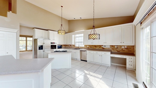 kitchen featuring tasteful backsplash, appliances with stainless steel finishes, a center island, and pendant lighting