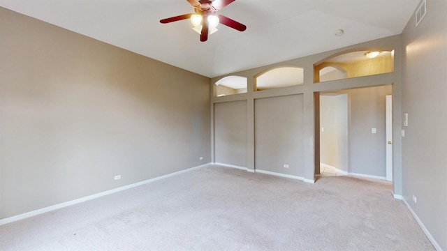 unfurnished bedroom featuring light carpet, lofted ceiling, a closet, and ceiling fan