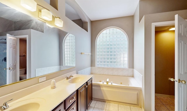 bathroom featuring tile patterned floors, toilet, vanity, and a washtub