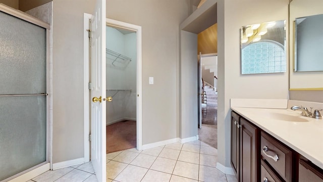 bathroom featuring vanity, a shower with shower door, and tile patterned flooring