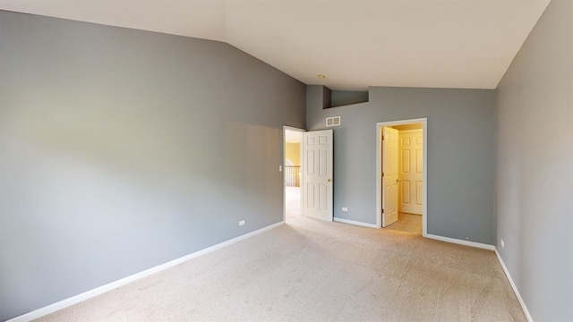 unfurnished bedroom featuring vaulted ceiling and light carpet