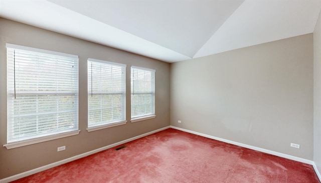 carpeted spare room with vaulted ceiling