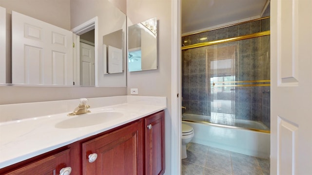 full bathroom featuring vanity, tile patterned floors, shower / bath combination with glass door, and toilet