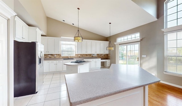 kitchen with white cabinetry, appliances with stainless steel finishes, a center island, and sink