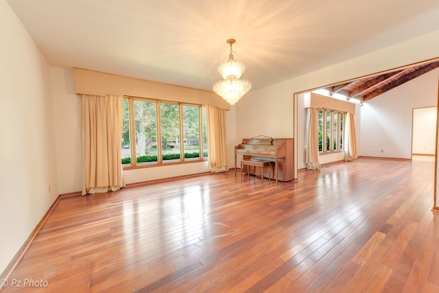 spare room featuring vaulted ceiling with beams, baseboards, a notable chandelier, and wood finished floors