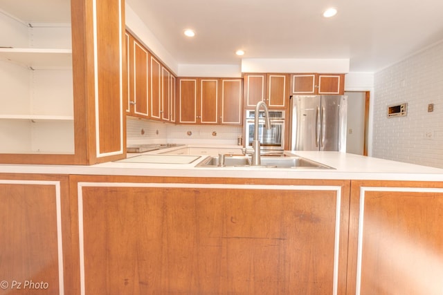 kitchen featuring stainless steel appliances, recessed lighting, tasteful backsplash, light countertops, and brown cabinetry