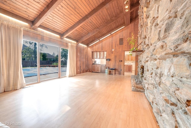 unfurnished living room with wood walls, wood ceiling, beamed ceiling, and wood finished floors