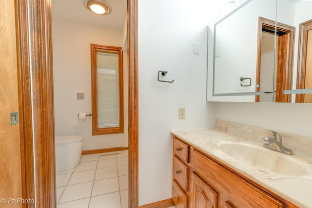 bathroom featuring baseboards, vanity, toilet, and tile patterned floors