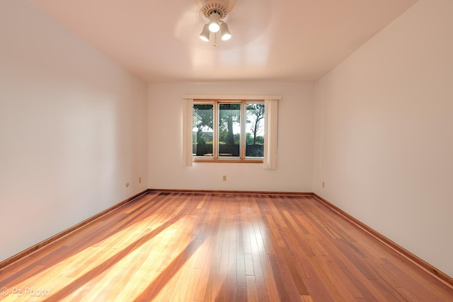 empty room with ceiling fan, baseboards, and hardwood / wood-style flooring