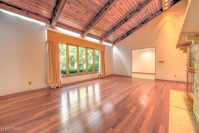 unfurnished living room featuring beam ceiling, wood-type flooring, track lighting, high vaulted ceiling, and wooden ceiling