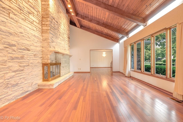 unfurnished living room featuring beamed ceiling, wood-type flooring, a fireplace, and visible vents