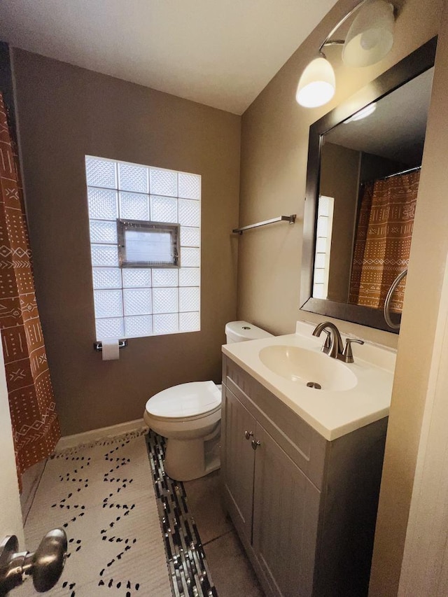 bathroom with tile patterned flooring, vanity, and toilet