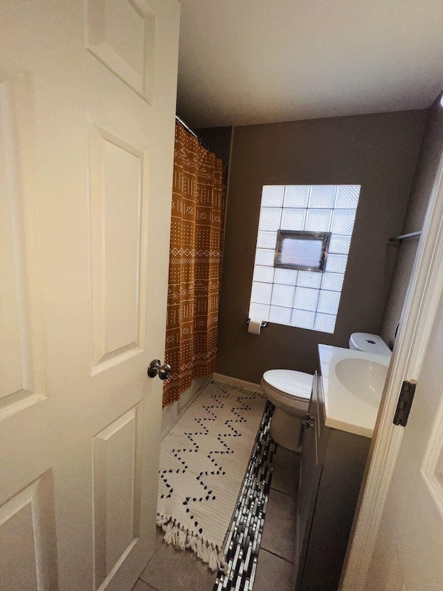 bathroom featuring vanity, curtained shower, tile patterned floors, and toilet