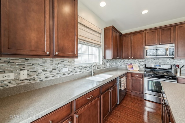 kitchen featuring stainless steel appliances, sink, backsplash, and dark hardwood / wood-style flooring