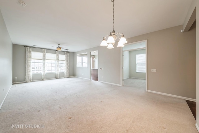 unfurnished room with ceiling fan with notable chandelier and light colored carpet