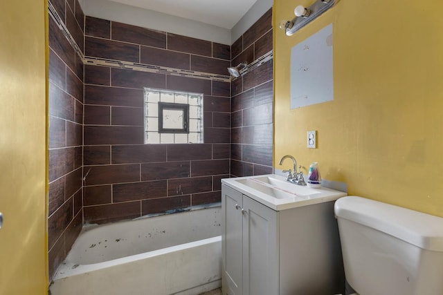 full bathroom featuring tiled shower / bath combo, vanity, and toilet