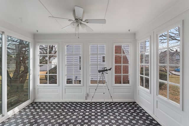 unfurnished sunroom with ceiling fan