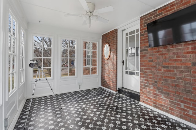 unfurnished sunroom with ceiling fan