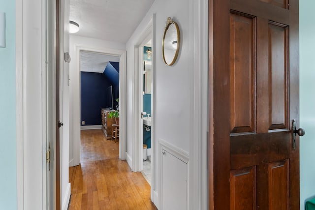 hallway with light hardwood / wood-style floors