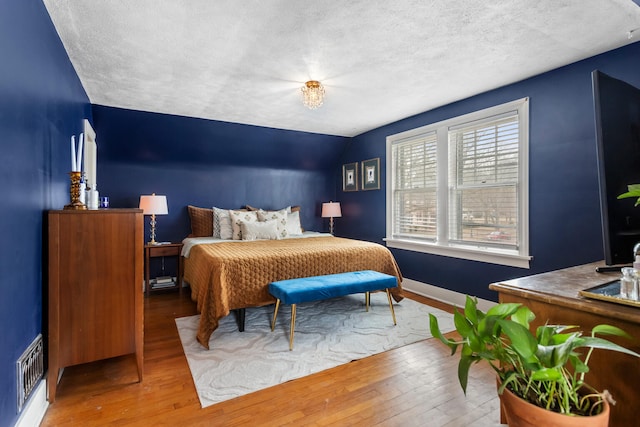 bedroom with hardwood / wood-style floors and a textured ceiling