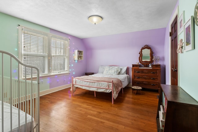 bedroom featuring hardwood / wood-style floors and a textured ceiling