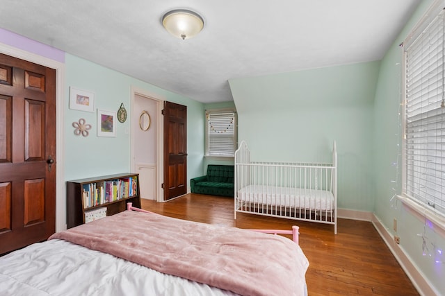 bedroom with hardwood / wood-style flooring and multiple windows