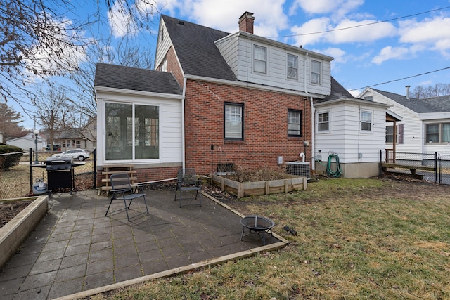 rear view of property featuring central AC, a patio, a yard, and a fire pit