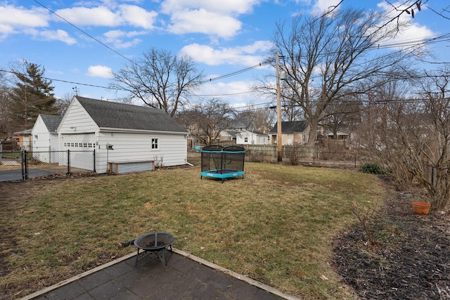 view of yard with an outbuilding, an outdoor fire pit, a trampoline, and a garage