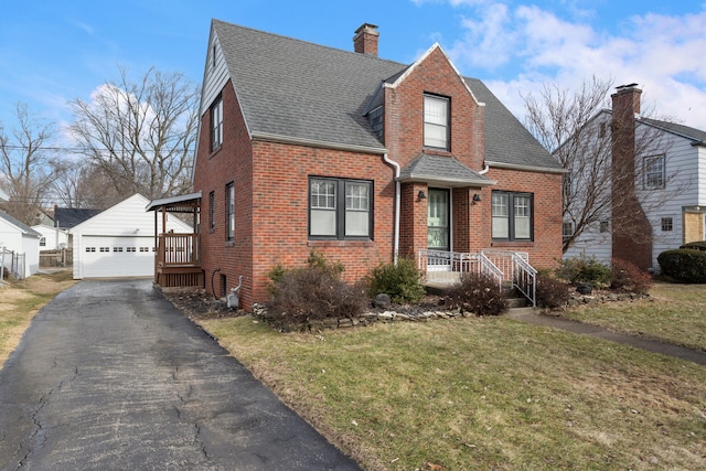 view of front of property with a garage, an outbuilding, and a front lawn