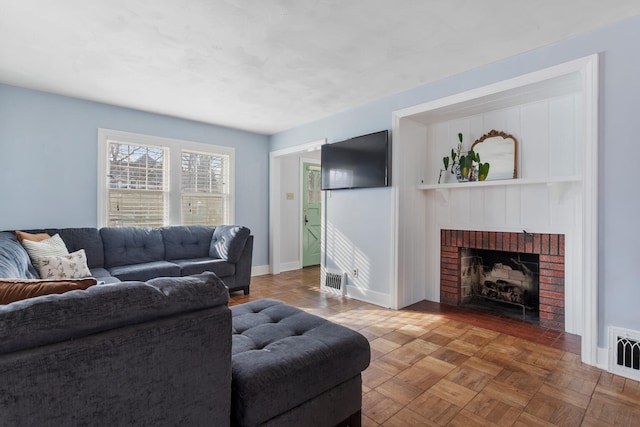 living room with a brick fireplace and parquet flooring