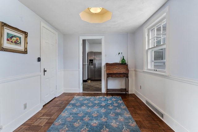 hallway featuring dark parquet flooring