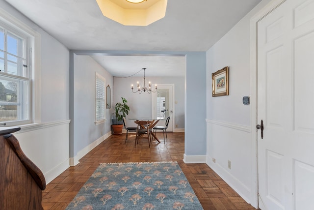 dining room with a notable chandelier and dark parquet floors