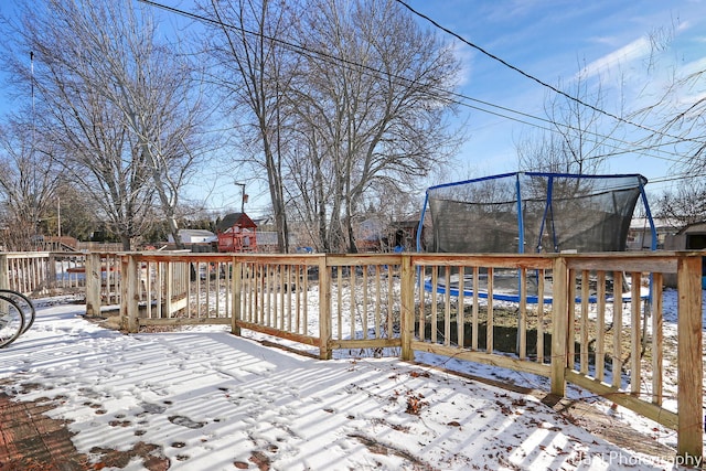 snow covered deck featuring a trampoline and a playground