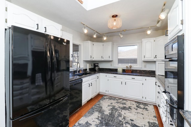 kitchen featuring sink, dark stone countertops, white cabinets, dark hardwood / wood-style flooring, and black appliances