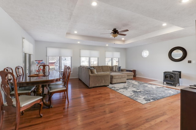 living room with a raised ceiling, hardwood / wood-style floors, and a textured ceiling